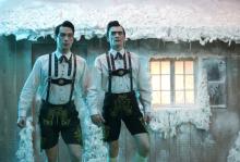 Two brothers walk in the snow outside their cottage in lederhosen